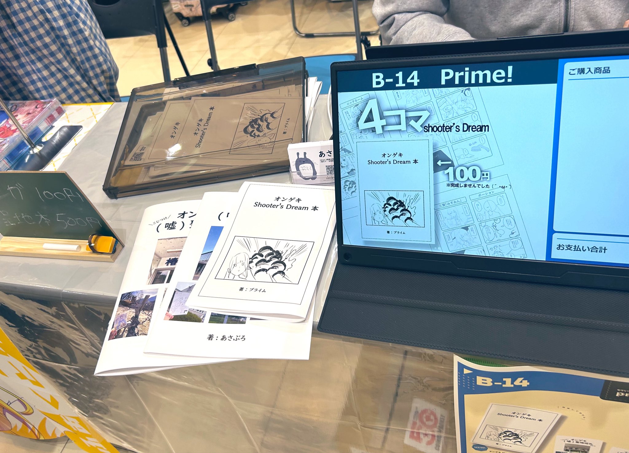セゲいち20のB-14 Prime!スペース。4コマ本と巡礼本、会計用モニターが並ぶ売り場